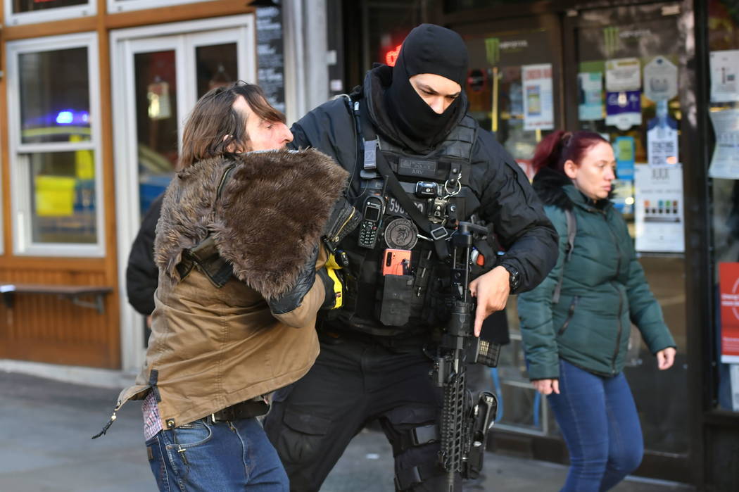 A police officer moves an uninvolved person away from a cordon after an incident on London Brid ...
