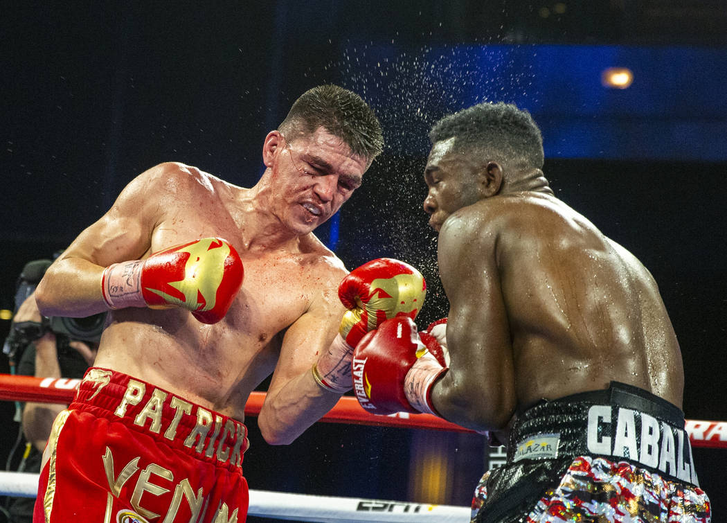 Patrick Teixeira, left, connects with the chin of Carlos Adames during round 8 in their super w ...