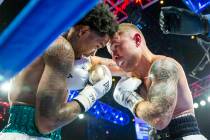 Tyler McCreary, left, takes a hit from Carl Frampton during round 4 of their WBC super featherw ...