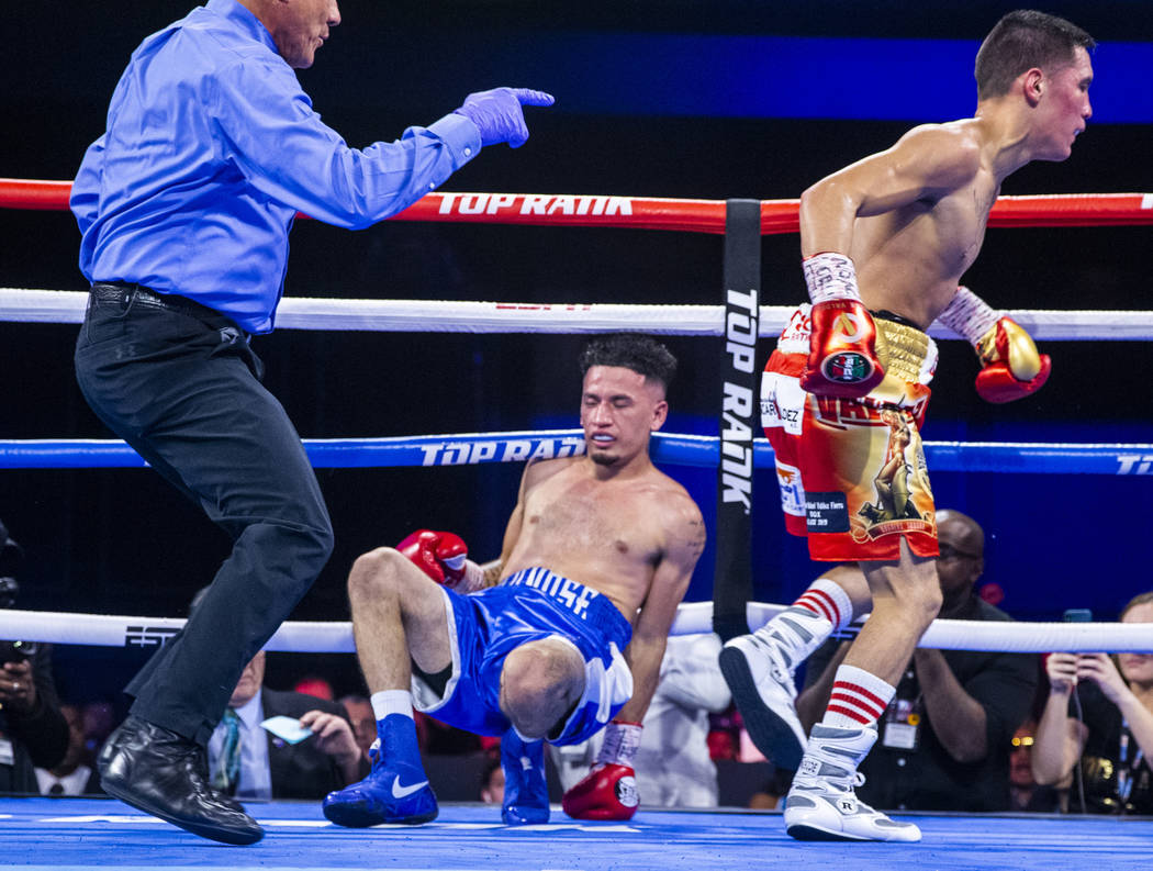 Adam Lopez, left, is down on the ropes as Oscar Valdez is sent to the corner during a knock dow ...