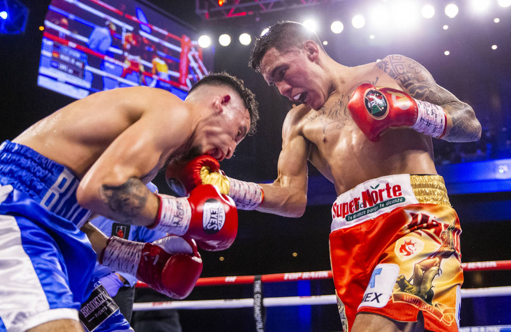 Adam Lopez, left, takes a right to the chin by Oscar Valdez during round 7 of their WBC super f ...