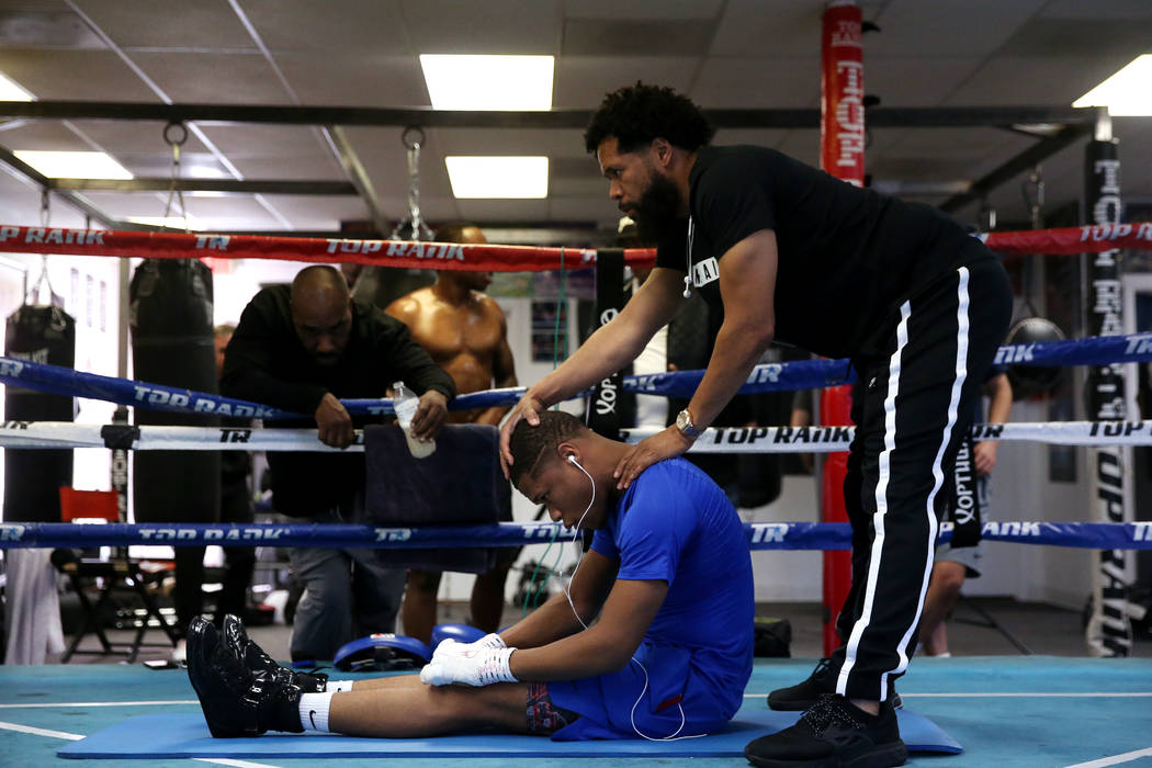 Boxer Devin Haney, left, with his father and trainer William "Bill" Haney, stretch be ...