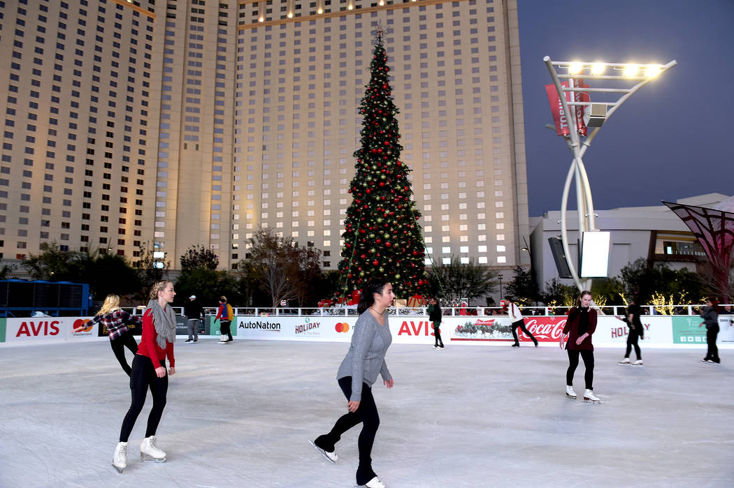 Skaters enjoy the ice rink set up in Toshiba Plaza during The Park’s first-ever tree-lighting ...