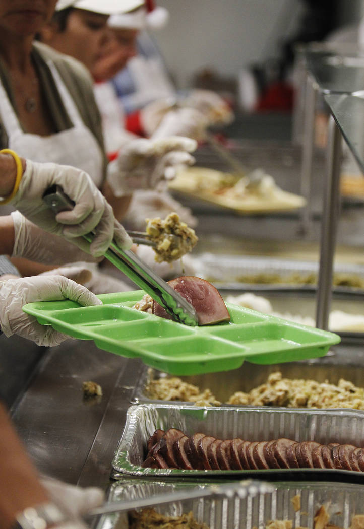 Volunteers prepare holiday meals during the annual Christmas Eve dinner at the Las Vegas Rescue ...