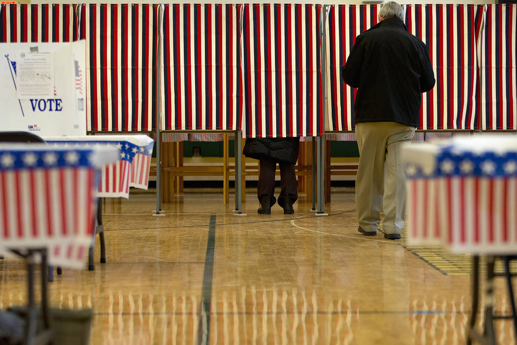 People cast their votes in the presidential primary at Windham High School in Windham, N.H., Tu ...