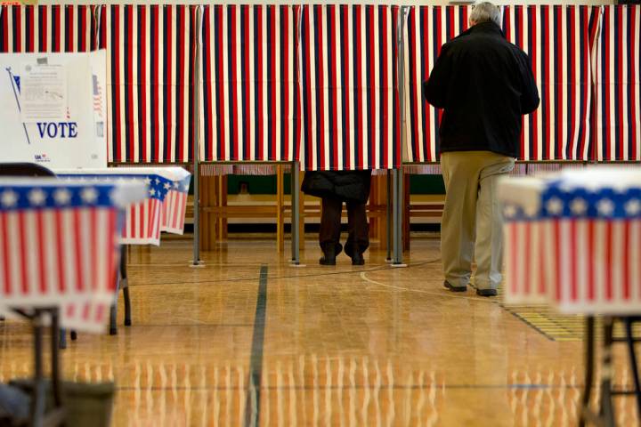 People cast their votes in the presidential primary at Windham High School in Windham, N.H., Tu ...