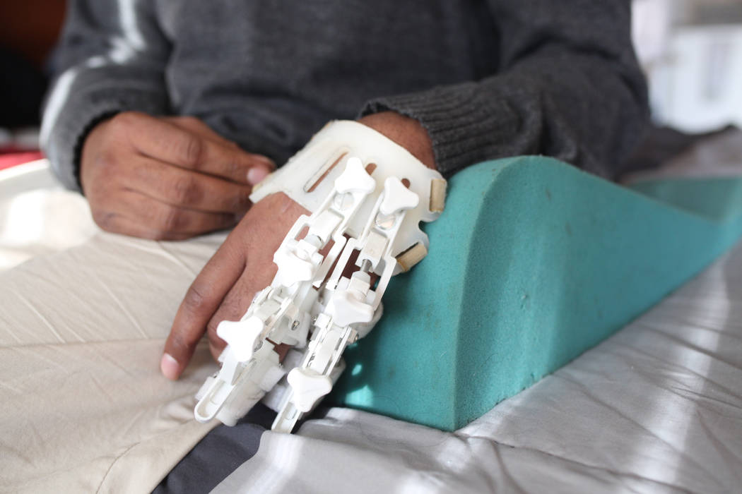 Jeffrey Fikes relaxes on his bed with his splint and foam rest, in his supportive housing unit ...