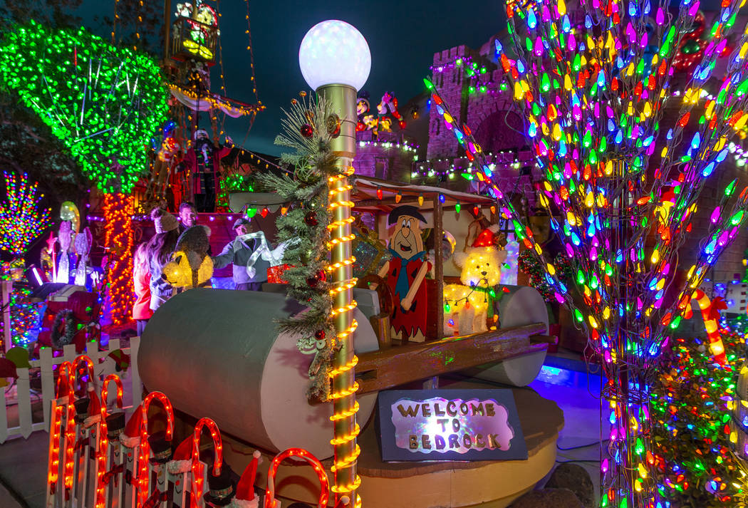 Fred Flintstone in his car is apart of the holiday lights display in the yard of Maria Acosta a ...