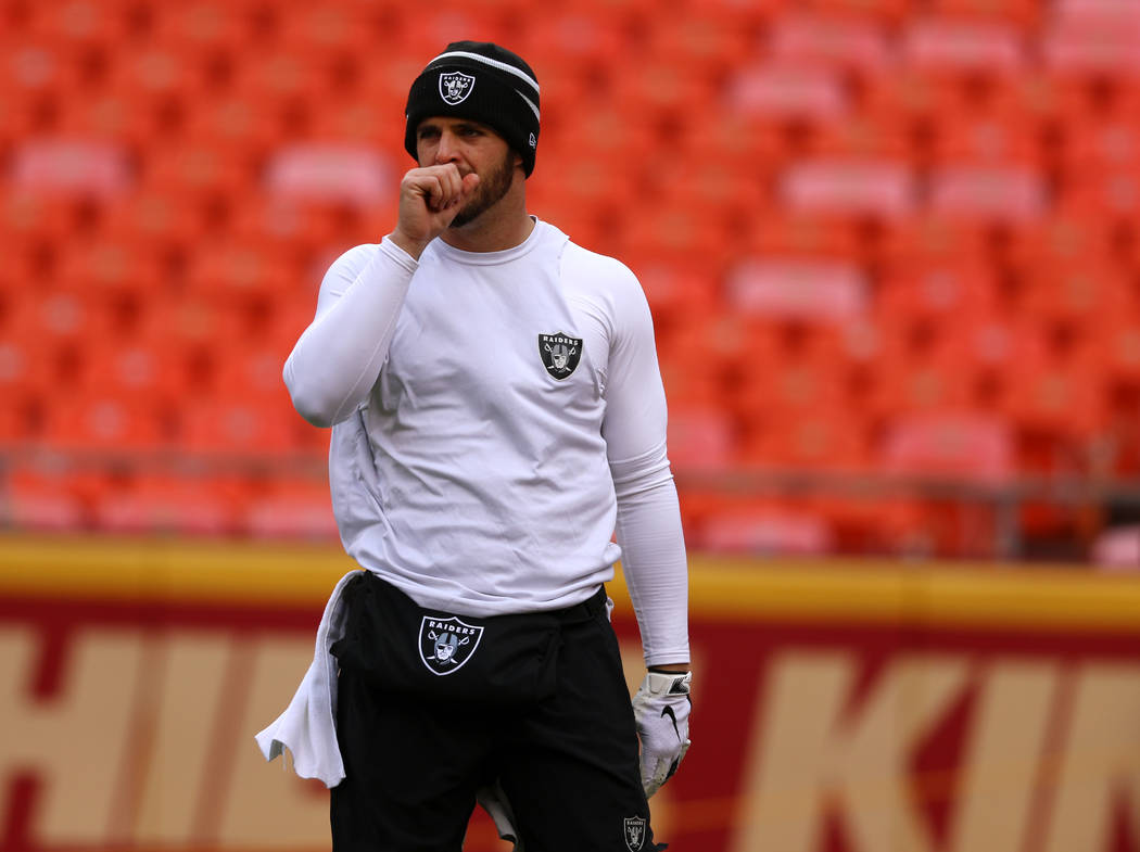 Oakland Raiders quarterback Derek Carr blows into his hand during warm ups prior to an NFL game ...