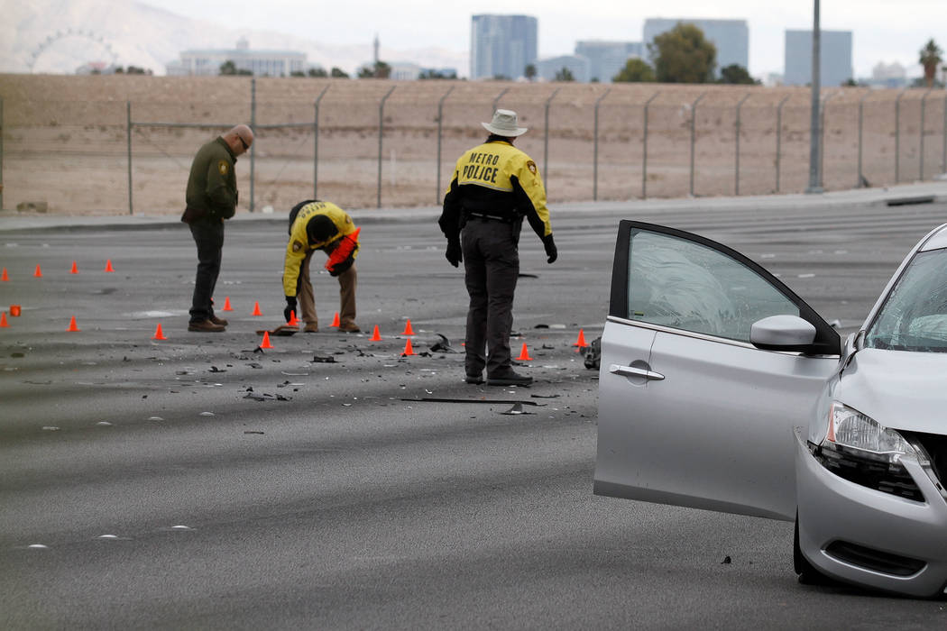 Las Vegas police officers investigate a fatal crash at Durango Drive and Russell Road in southw ...