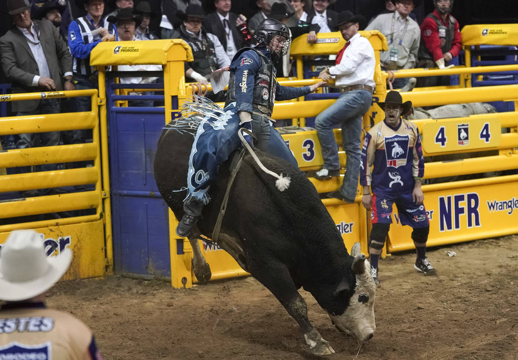 Joe Frost of Randlett, Utah (103) competes in the bull riding event during the eighth go-round ...