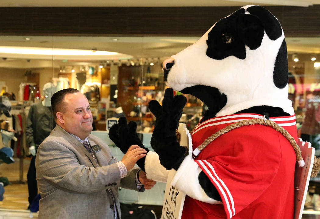 Scott Murray, general manager at Chick-fil-A, chats with Chick-fil-A's mascot, the cow, at the ...