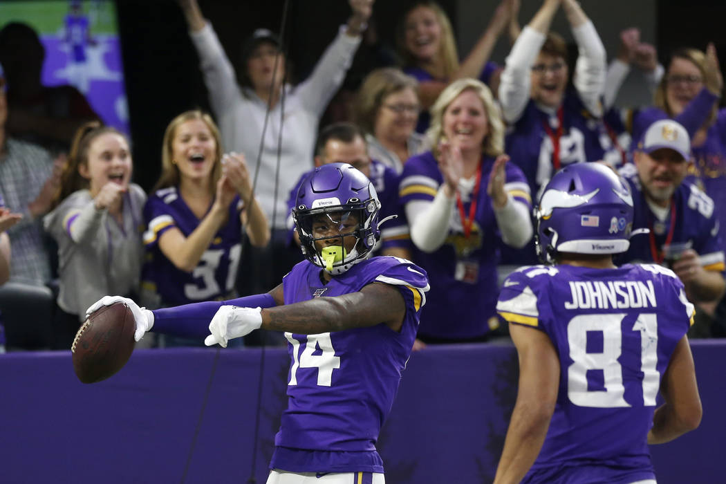 Minnesota Vikings wide receiver Stefon Diggs (14) celebrates with teammate Bisi  Johnson, right, …