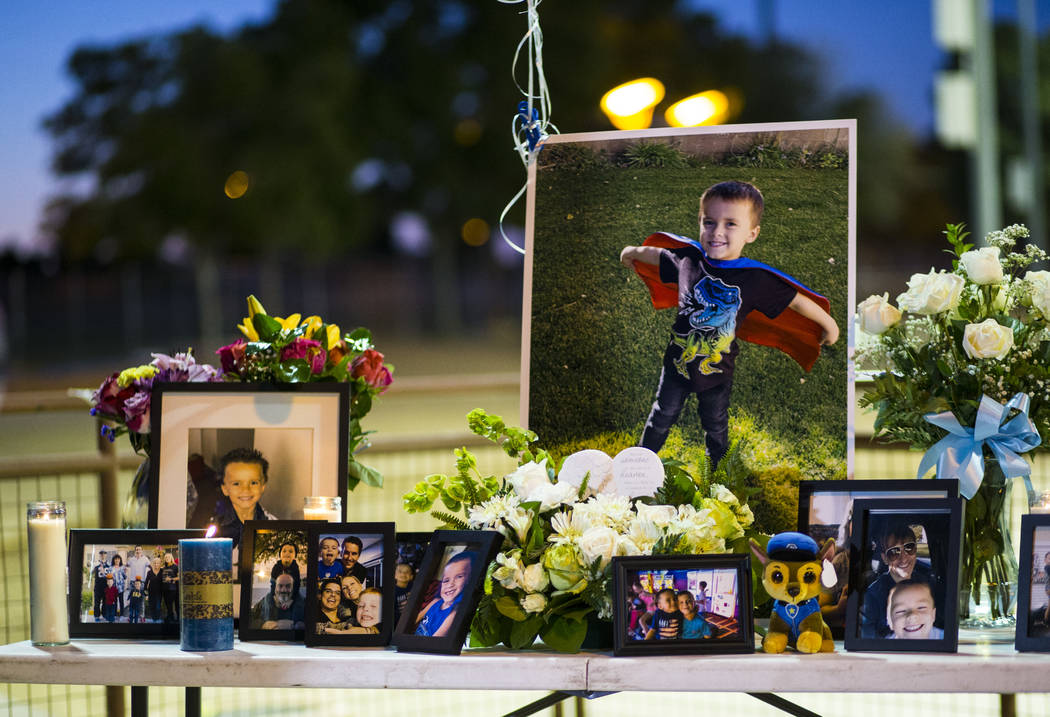 Photos of Gavin Murray Palmer, who was lost in a house fire, during a candlelight vigil in his ...