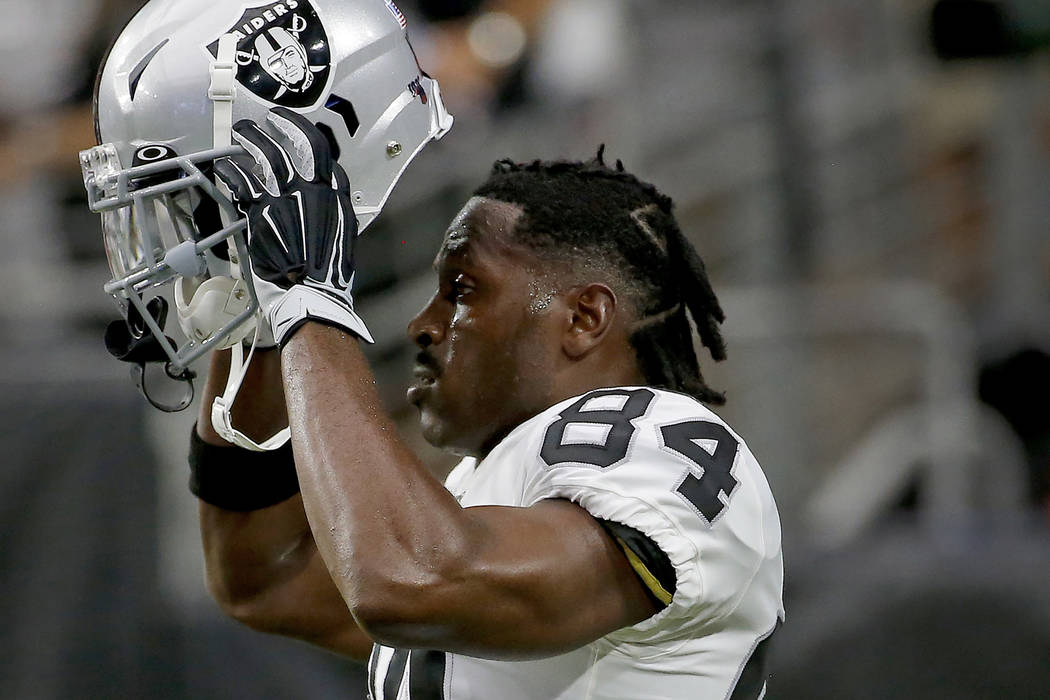 FILE - In this Aug. 15, 2019, file photo, Oakland Raiders wide receiver Antonio Brown (84) puts ...