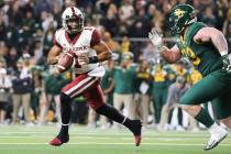 Oklahoma quarterback Jalen Hurts, left, rolls away from the pressure by Baylor defensive tackle ...