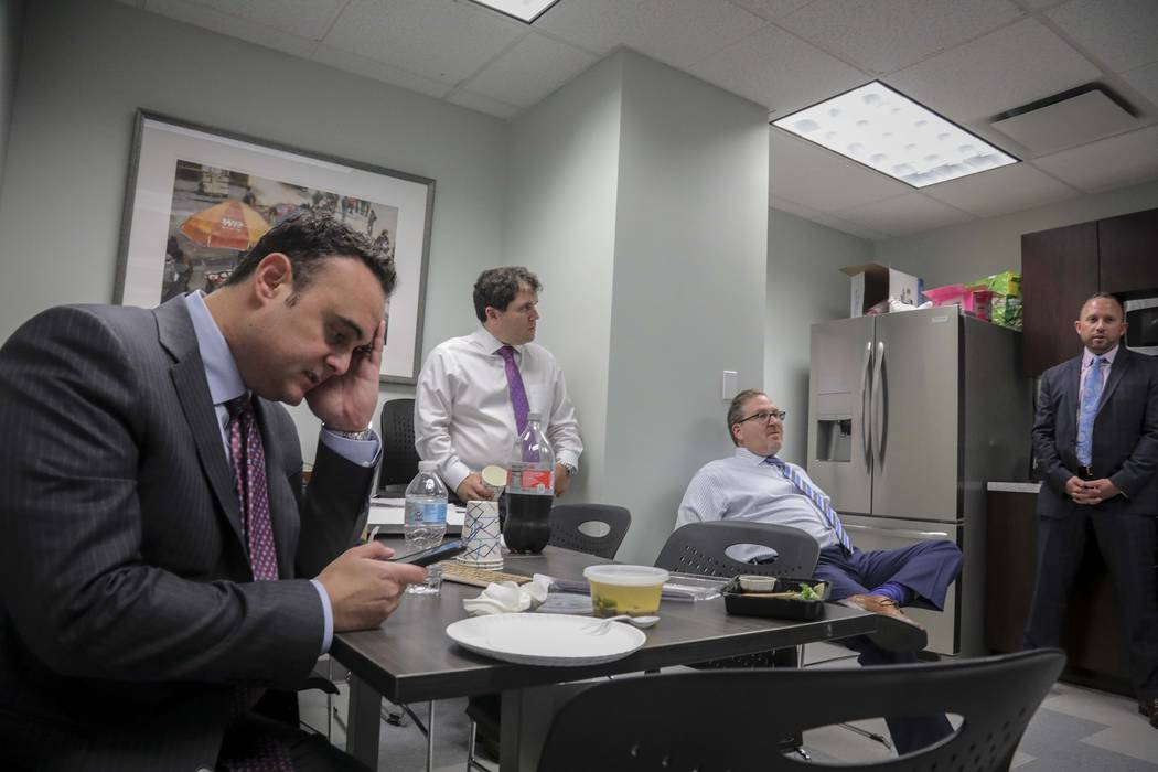 In a Tuesday, Oct. 29, 2019, photo, attorney Adam Slater, left, checks his phone during a worki ...