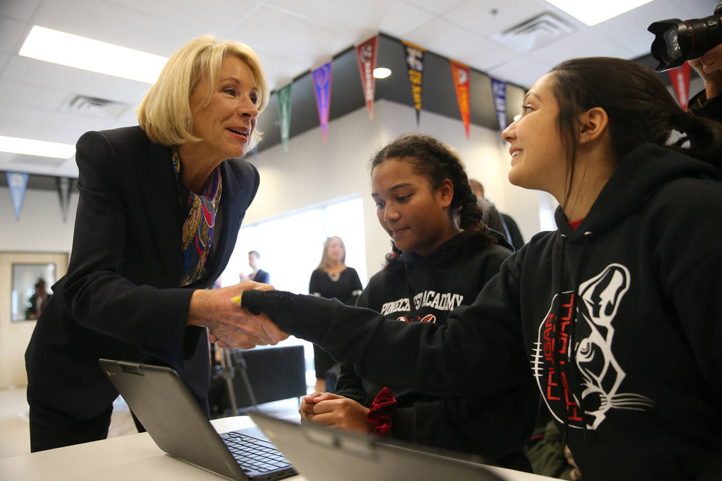 Secretary of Education Betsy DeVos, from left, speaks to 10th graders Sonaya Fernandes, 15, and ...