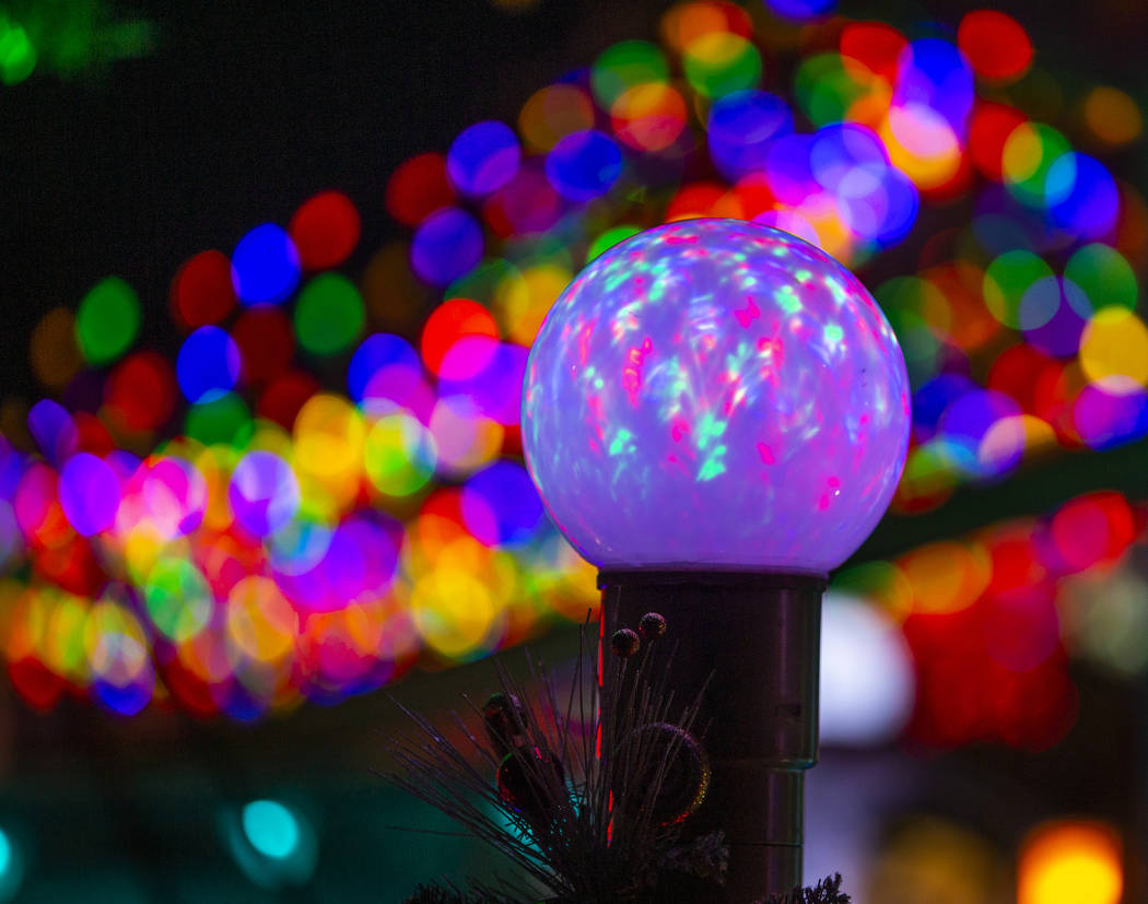 An illuminated globe as part of the holiday lights display in the yard of Maria Acosta and Juan ...
