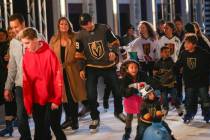Golden Knights' Alex Tuch, center left, skates with hockey fans during the "Night With the ...