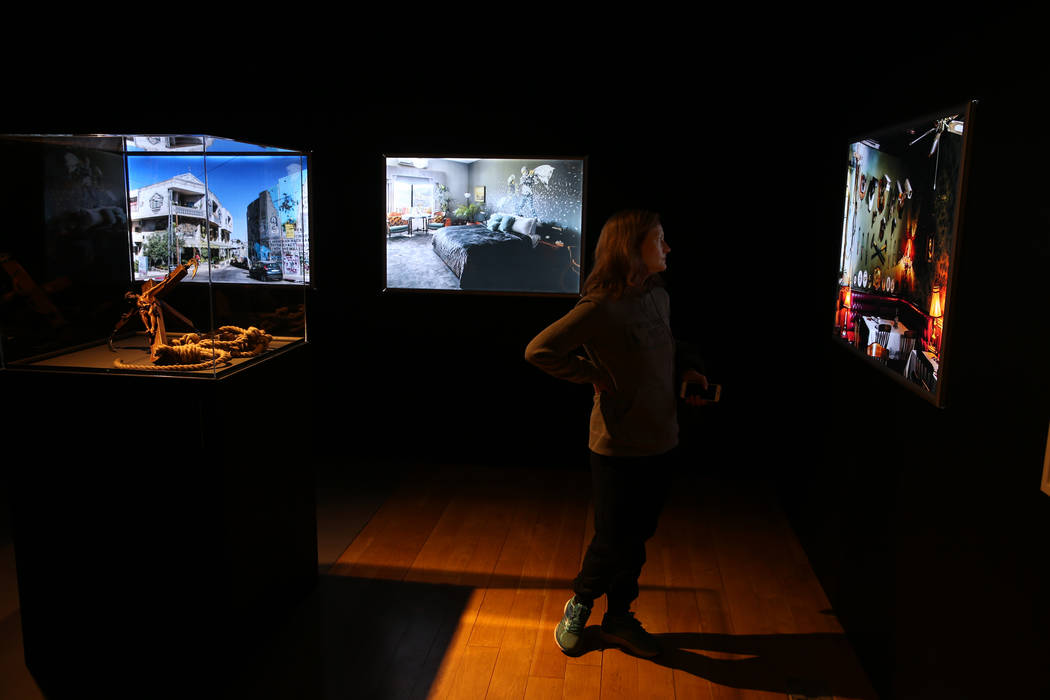 Tiff Feldman of Canada checks out images of Banksy's The Walled Off Hotel in Bethlehem on displ ...