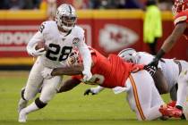 Oakland Raiders running back Josh Jacobs (28) tries to break a tackle by Kansas City Chiefs def ...