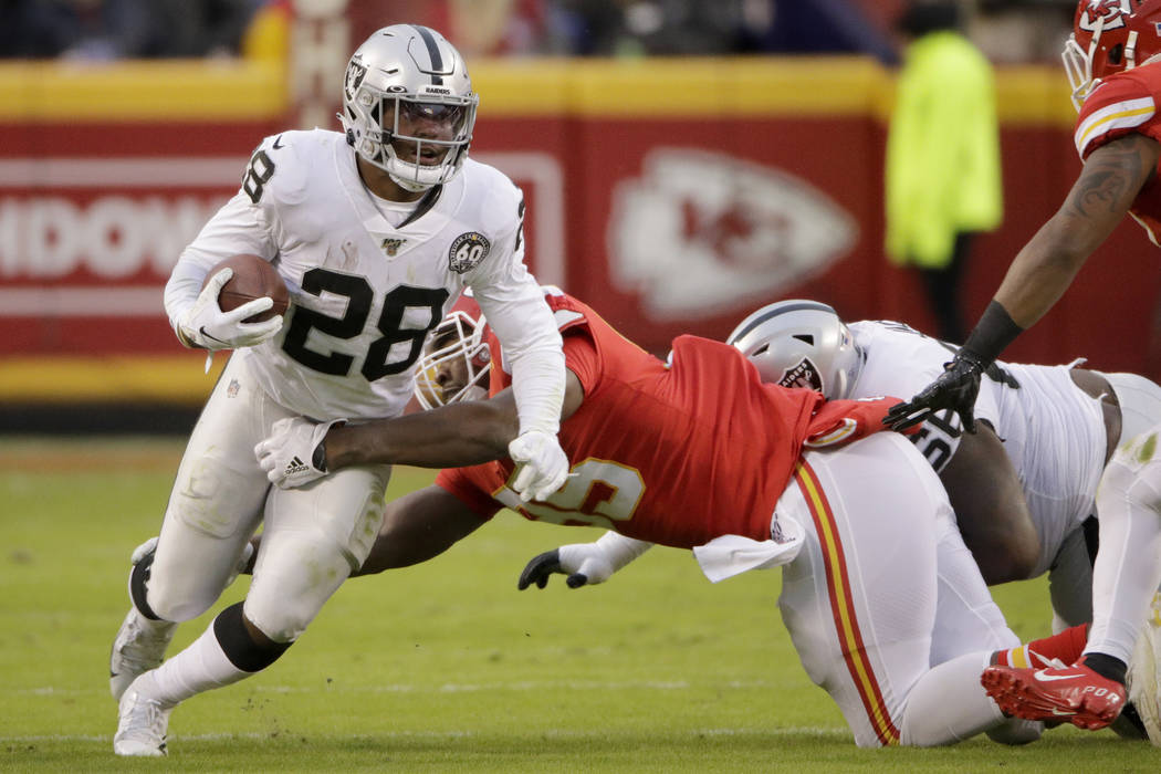 Oakland Raiders running back Josh Jacobs (28) tries to break a tackle by Kansas City Chiefs def ...