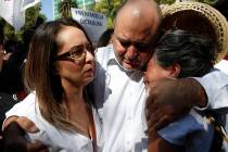 Julian LeBaron, center, embraces Erika Garcia, left, and another woman before a protest against ...