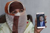 In a May 22, 2019, file photo, Sumaira a Pakistani woman, shows a picture of her Chinese husban ...