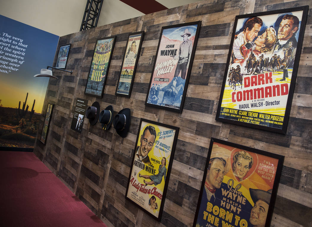Framed movie posters staring film icon John Wayne line the walls at the "John Wayne: Spirit of ...