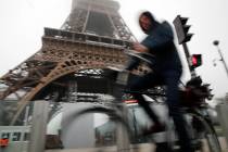 A man rides his bicycle in front of the closed Eiffel Tower in Paris, Thursday, Dec. 5, 2019. T ...