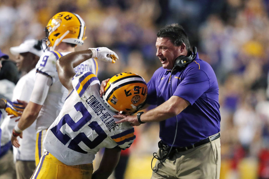 LSU coach Ed Orgeron celebrates with running back Clyde Edwards-Helaire  (22) after a touchdown …