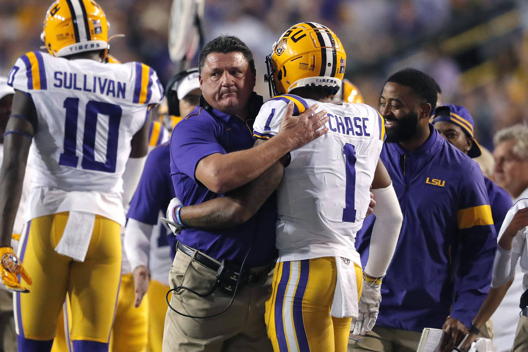 LSU coach Ed Orgeron hugs wide receiver Ja'Marr Chase (1) on the sideline after his touchdown r ...