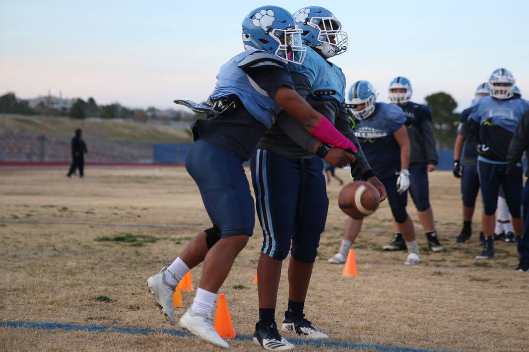 Centennial's Leonard Robbs, left, and Sam Norris, run a drill during a team practice at Centenn ...