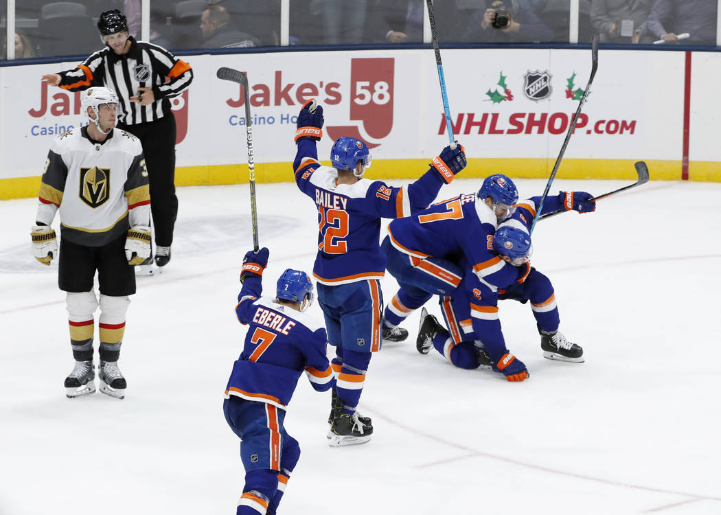 New York Islanders left wing Anders Lee (27) tackles defenseman Ryan Pulock (6), who scored in ...