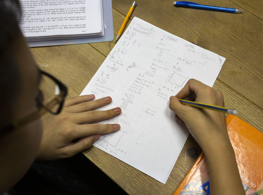 UNLV student Shenlone Wu, 12, works on math proofs for fun at his parents' medical office in La ...