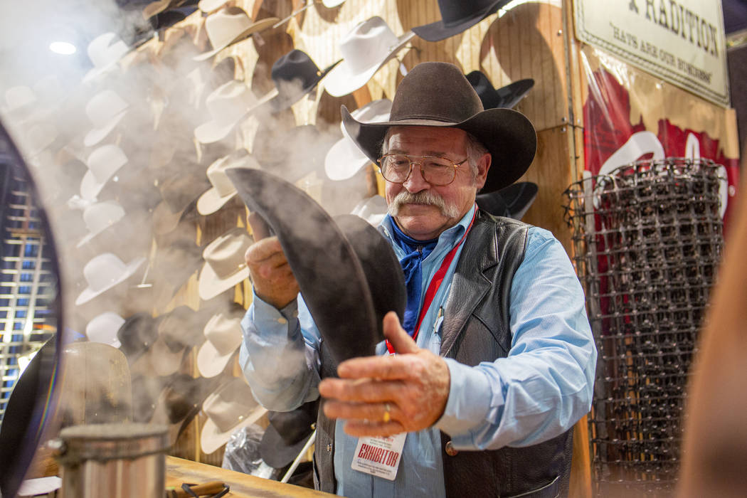 Owner of Western Tradition Rick Bishop cleans and reshapes a hat during Cowboy Christmas at the ...