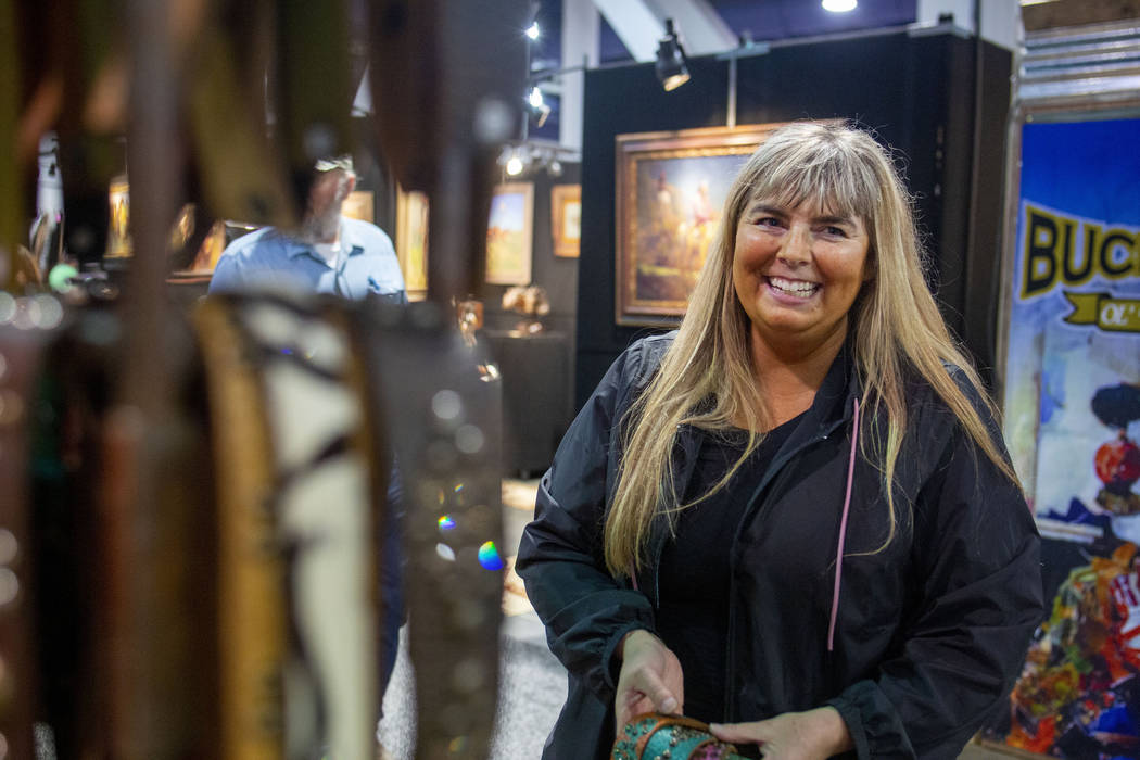 Owner of McFadin Leather Goods Laurie McFadin of Sabinal, Texas, hangs handmade leather straps ...