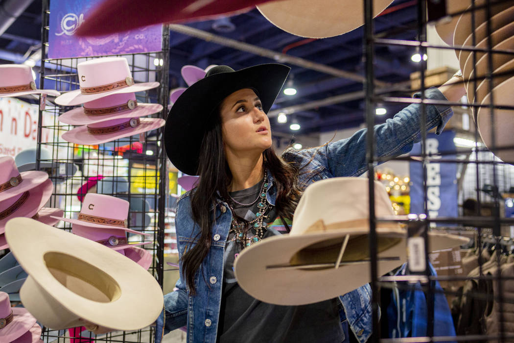 Kylee Hamilton of Texas, marketing for Charlie 1 Horse, organizes felt hats available for purch ...