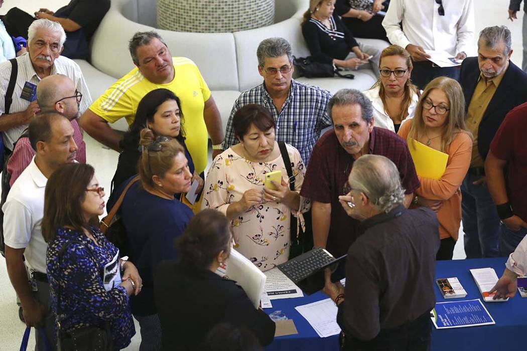 In a Sept. 18, 2019, file photo people inquire about temporary positions available for the 2020 ...