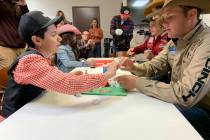 Angelo Mayorga, left, and Wrangler NFR tie-down roper Caleb Smidt work together on a project Fr ...