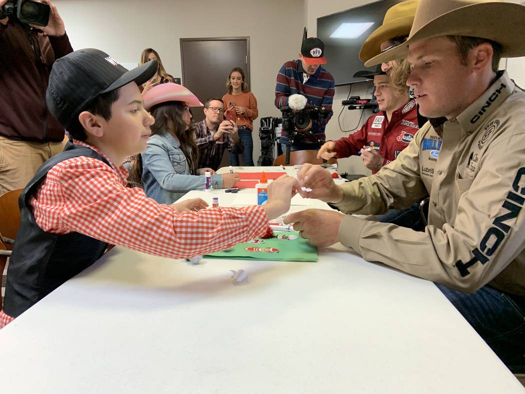 Angelo Mayorga, left, and Wrangler NFR tie-down roper Caleb Smidt work together on a project Fr ...