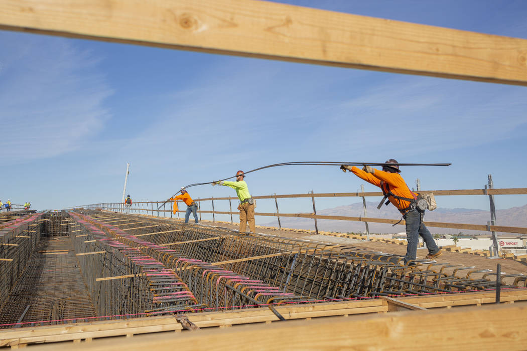 Steel workers put in rods during construction on the Centennial Bridge linking the eastbound 21 ...