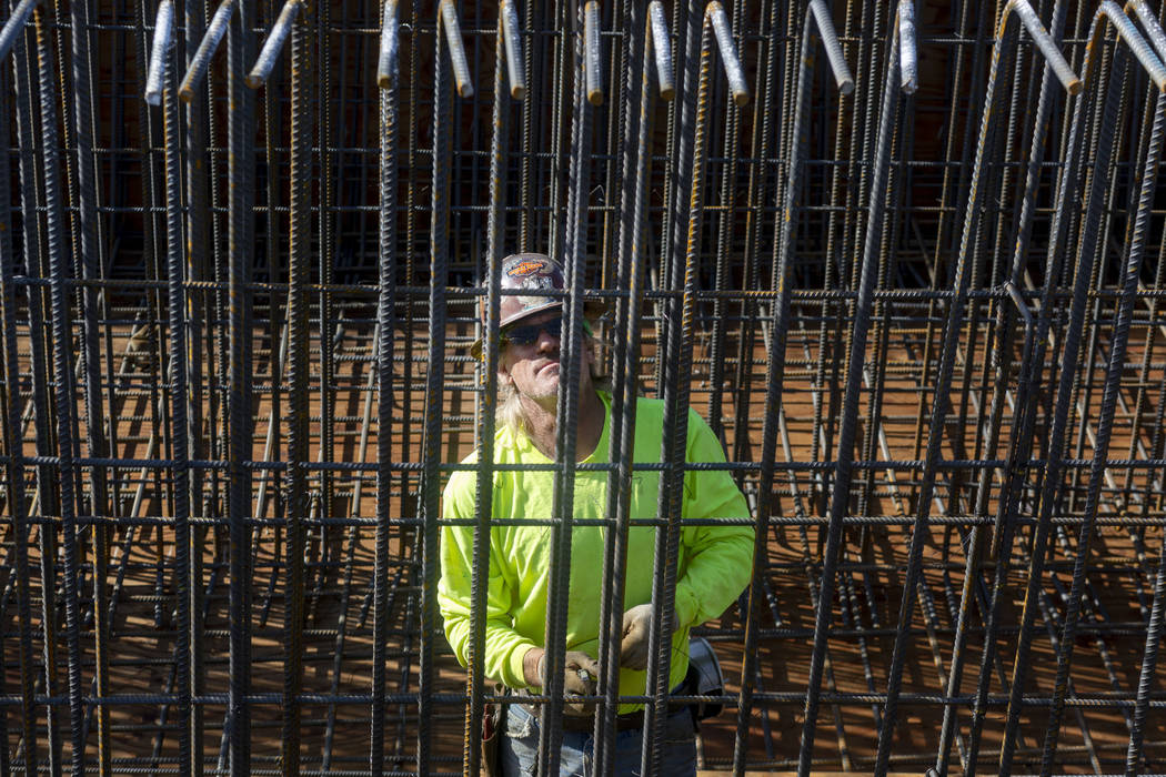 Steel worker Scott McBride puts in rods during construction on the Centennial Bridge linking th ...