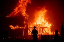 A home burns as a wildfire called the Camp Fire rages through Paradise, Calif., in November 201 ...