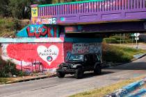 A vehicle drives by a tribute to victims of the Naval Air Station Pensacola that was freshly pa ...