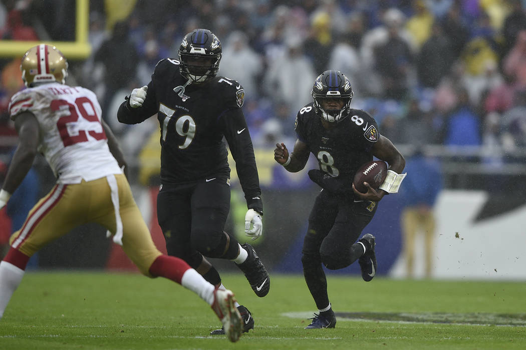 Baltimore Ravens quarterback Lamar Jackson runs the ball against the San Francisco 49ers in the ...