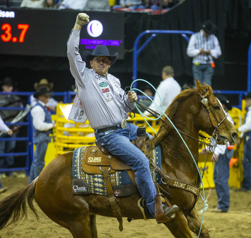 Heeler Cole Davison of Stephenville, Texas, celebrates a winning time in Team Roping with heade ...