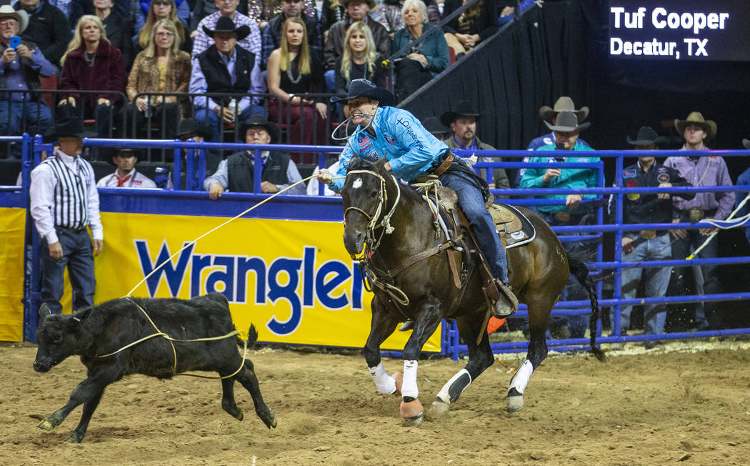 Tuf Cooper of Decatur, Texas, ropes a steer while taking first place in Tie-Down Roping with a ...