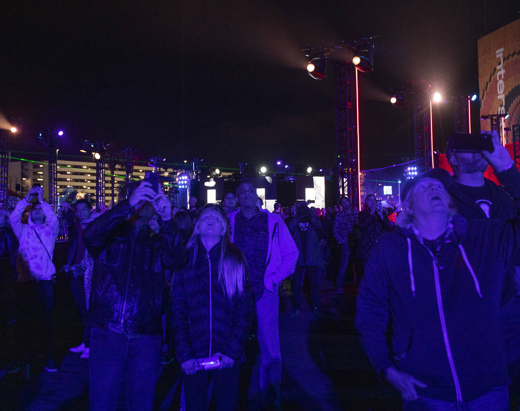 Festival-goers look up at The Expanse Drone Space Opera performance on Saturday, Dec. 7, 2019, ...